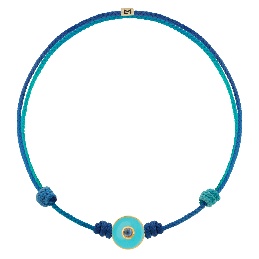 LUIS MORAIS 14k yellow gold small enameled Evil Eye disk with a blue Sapphire  gemstone in the center on an adjustable cord bracelet. Features a 14k yellow gold logo spacer.