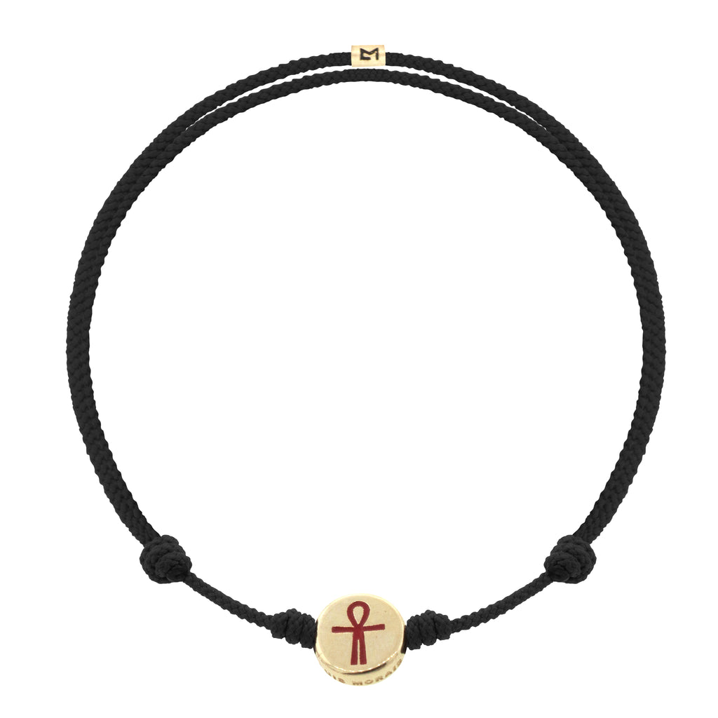 LUIS MORAIS 14K yellow gold small disk with a red enameled Ankh symbol on an adjustable cord bracelet. Features a 14K gold logo spacer.