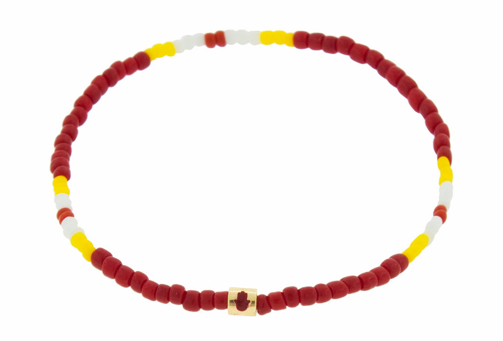LUIS MORAIS 14K yellow gold short roll with red enameled Hamsa symbol on a tribal beaded bracelet.