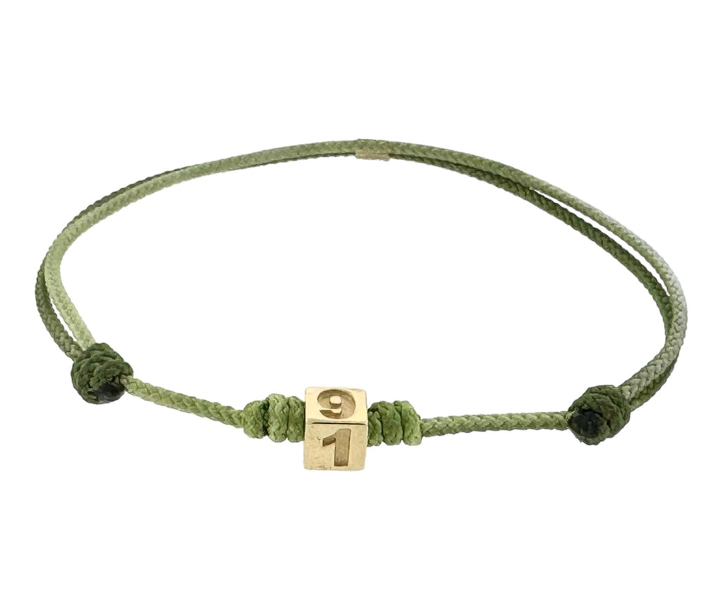 LUIS MORAIS 14K yellow gold cube with engraved 917 New York City area code and a ruby stone on a green ombre adjustable cord bracelet.
