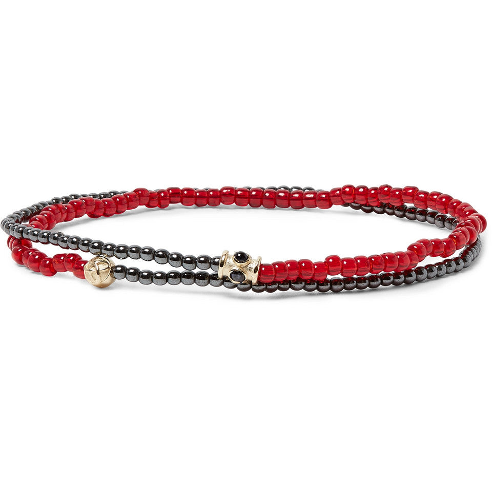 Two beaded bracelets, one red and one black, on a white background