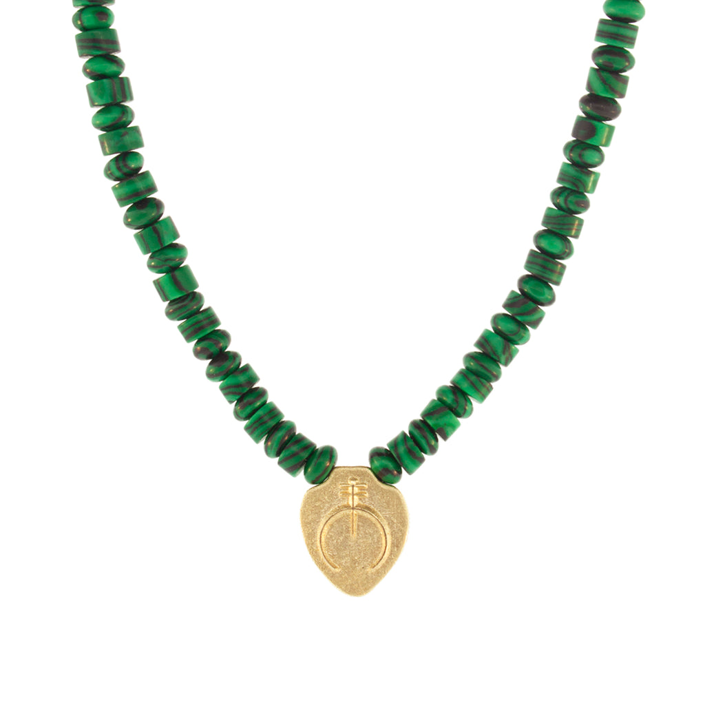 Luis Morais 14K yellow gold shield pendant with a Naja symbol on a malachite gemstone beaded necklace. 14K yellow gold long clasp closure.  The length of this necklace is 18 inches, if you would like a different length, please reach out to customer service. 