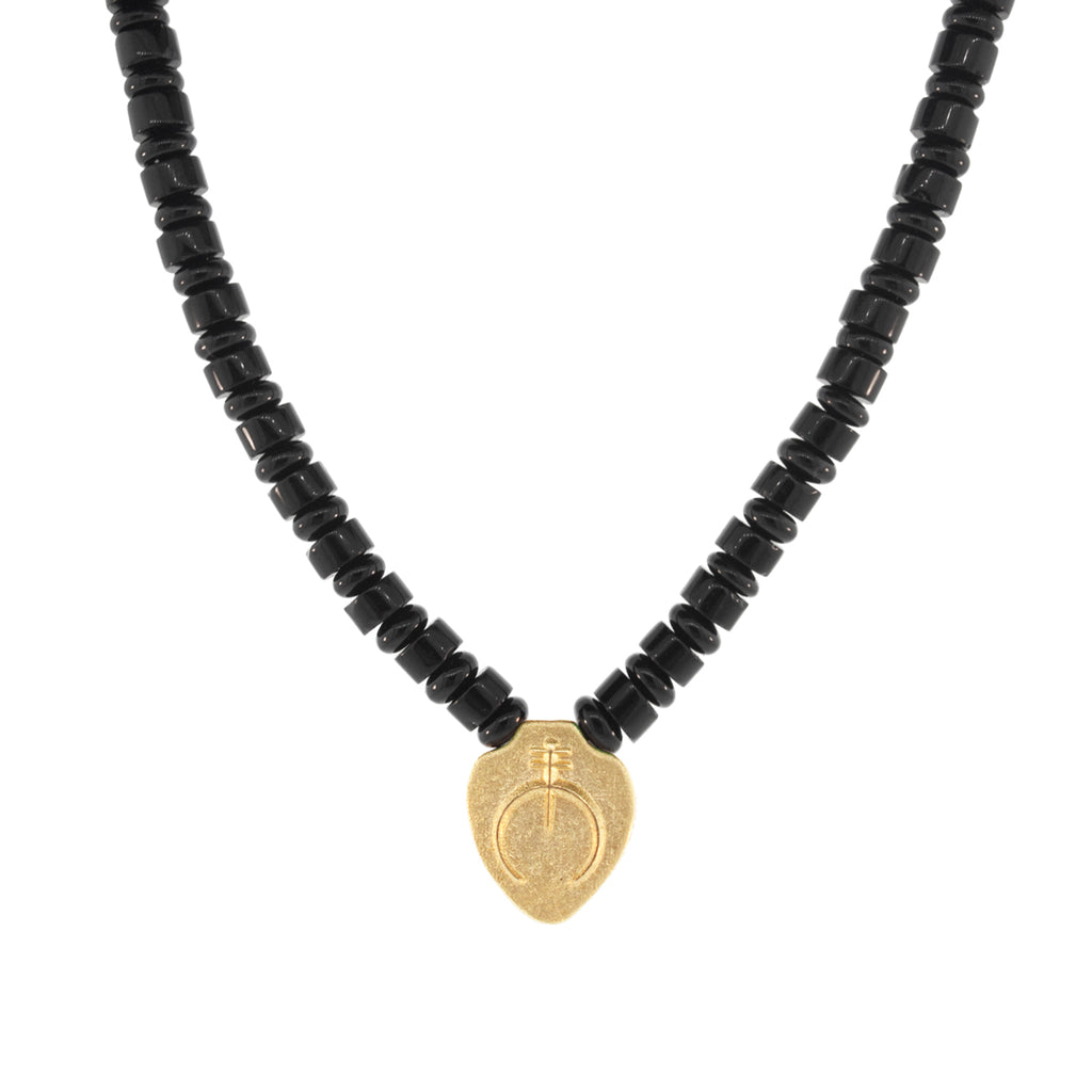 Luis Morais 14K yellow gold shield pendant with an Naja symbol on an onyx gemstone beaded necklace. 14K yellow gold long clasp closure.  The length of this necklace is 18 inches, if you would like a different length, please reach out to customer service. 