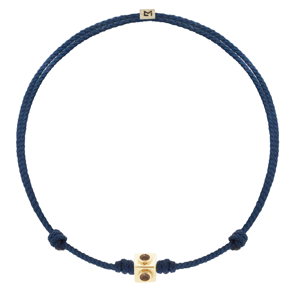 LUIS MORAIS 14k yellow gold small Lego cube (5mm) inlaid with four Citrine sides on an adjustable navy blue cord bracelet. Features a 14k yellow gold logo spacer.  *If you require a size that is not available in the options provided, please indicate your preferred size in the designated text box during checkout.
