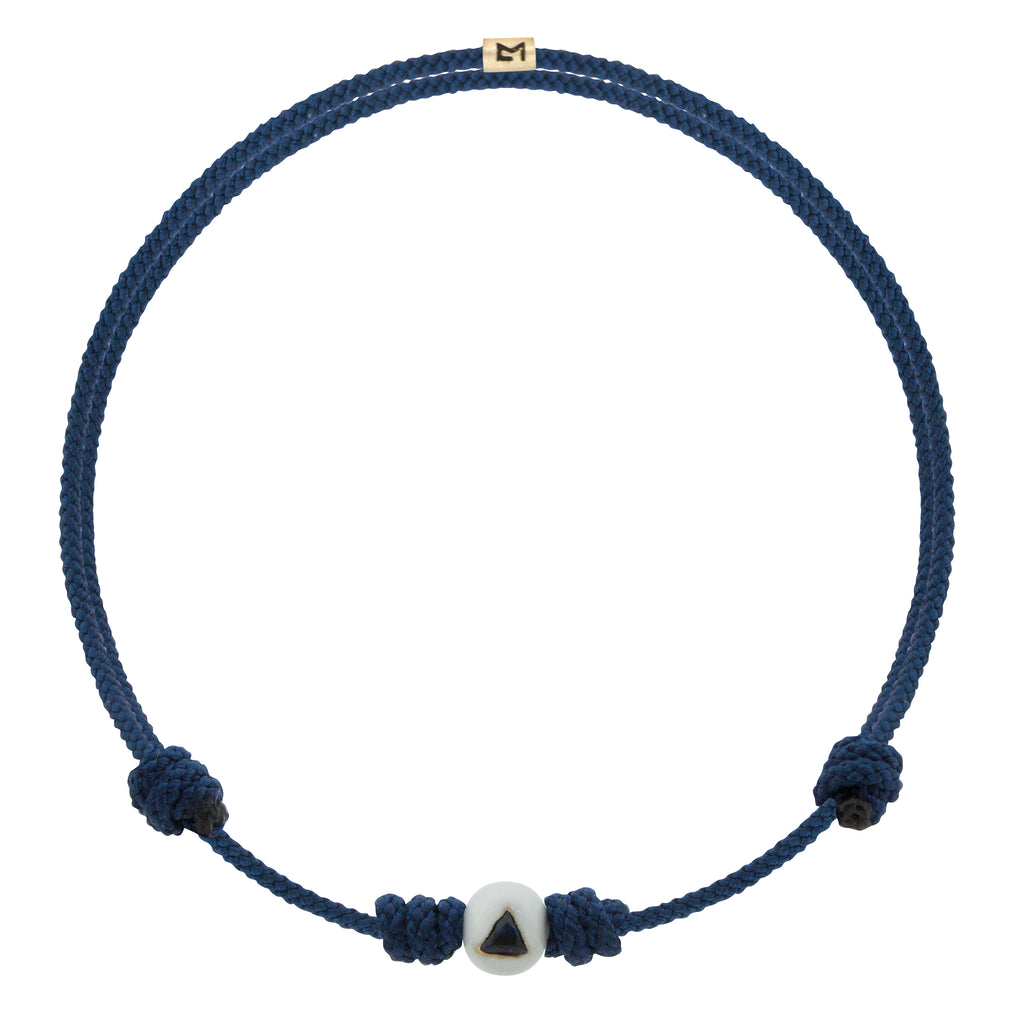 LUIS MORAIS 14K yellow gold enameled medium sized ball with a blue sapphire trillion on a cord bracelet.