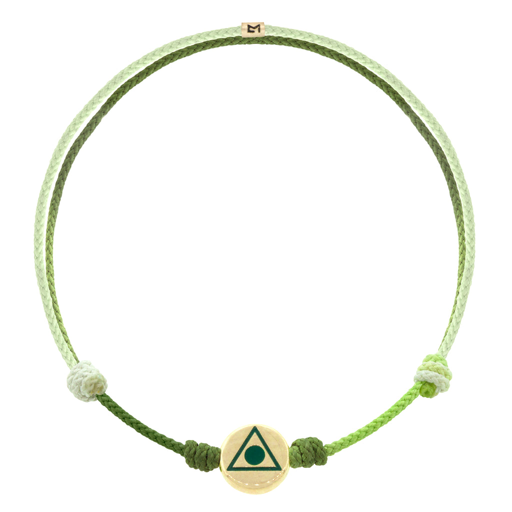 LUIS MORAIS 14K yellow gold small disk with a green enameled Light of the Majestic  symbol on an adjustable cord bracelet. Features a 14K gold logo spacer.