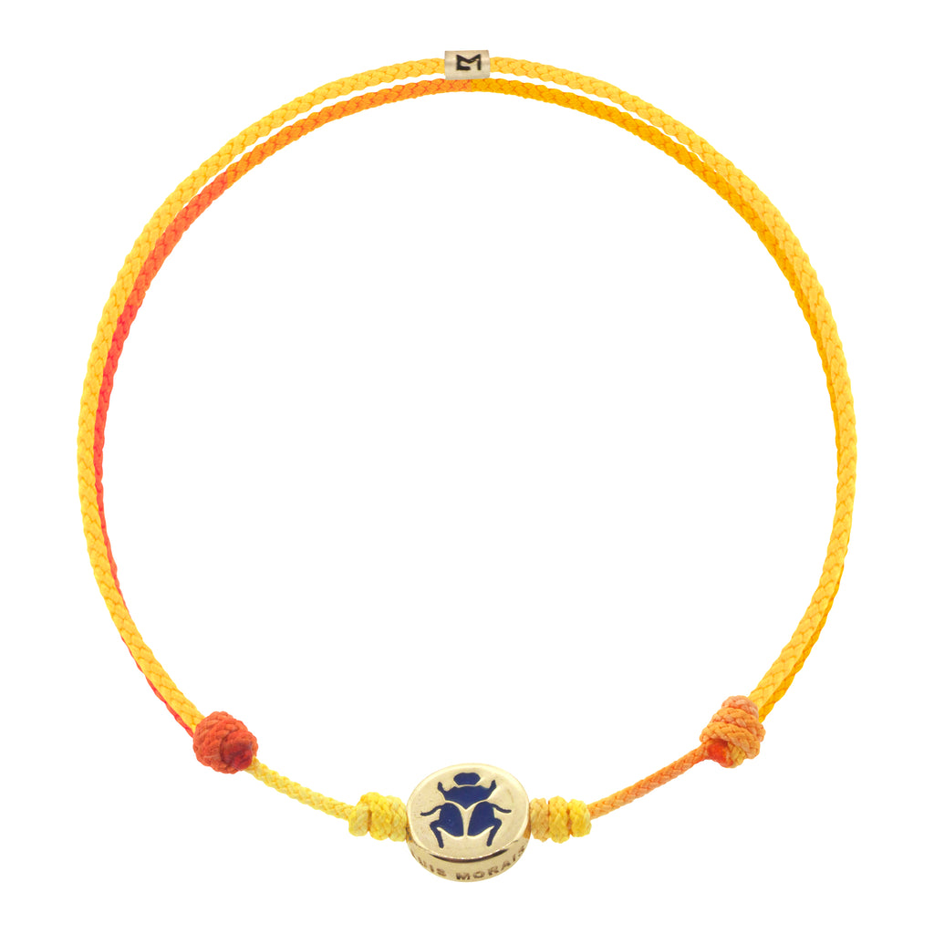 LUIS MORAIS 14K yellow gold small disk with a blue enameled scarab symbol on an adjustable cord bracelet. Features a 14K gold logo spacer.