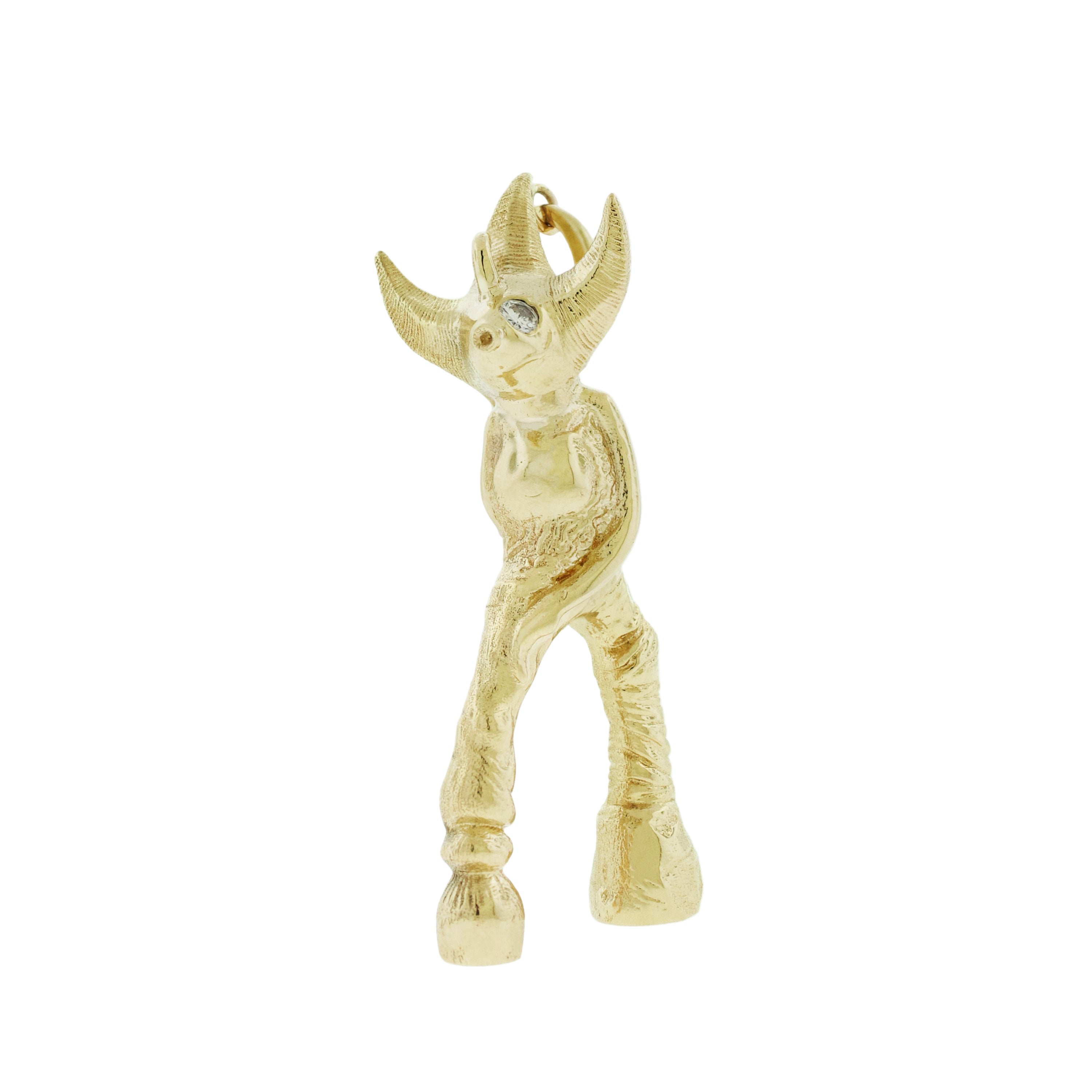 Gold figurine of a creature with large ears on a white background