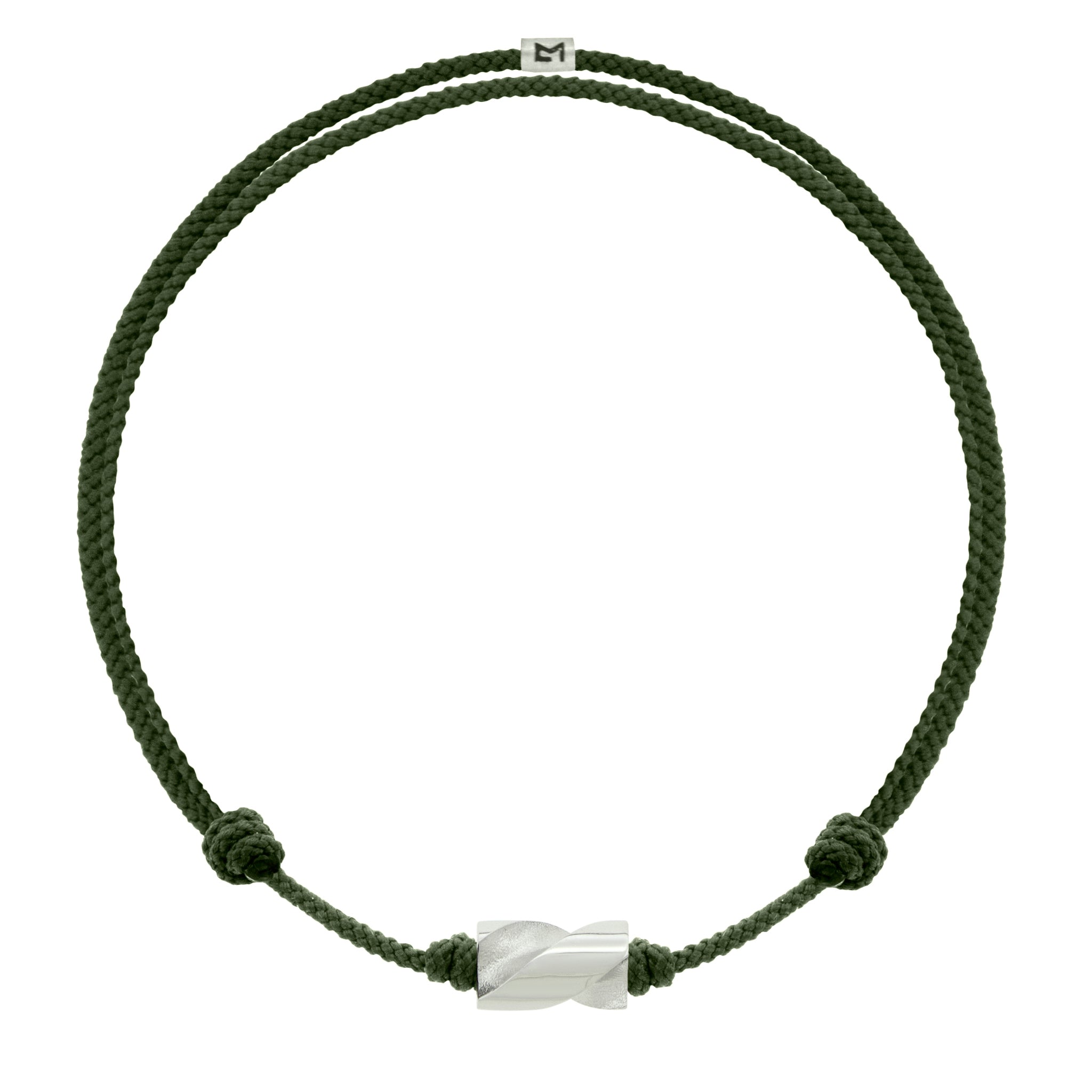 LUIS MORAIS 14k white gold long drill bit on an adjustable cord bracelet. The drill bit design is symbolic of digging deeper into oneself and life’s challenges. It represents resilience and the pursuit of discovery, encouraging the wearer to push through obstacles and uncover hidden truths.