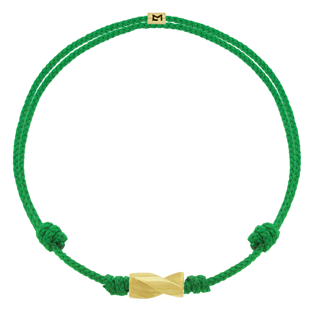 LUIS MORAIS 14k yellow gold long drill bit on an adjustable cord bracelet. The drill bit design is symbolic of digging deeper into oneself and life’s challenges. It represents resilience and the pursuit of discovery, encouraging the wearer to push through obstacles and uncover hidden truths.