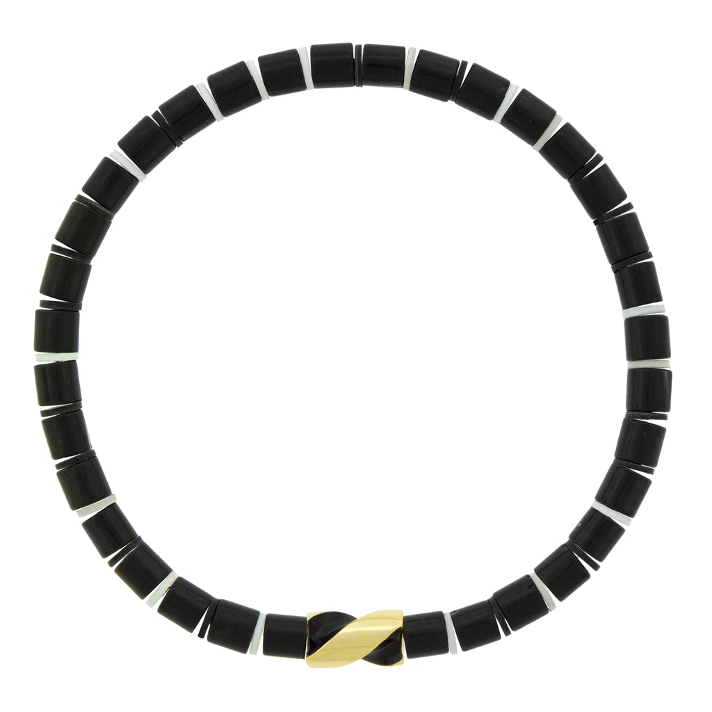 LUIS MORAIS 14k yellow gold enameled short drill bit on a gemstone beaded bracelet. The drill bit design is symbolic of digging deeper into oneself and life’s challenges. It represents resilience and the pursuit of discovery, encouraging the wearer to push through obstacles and uncover hidden truths.