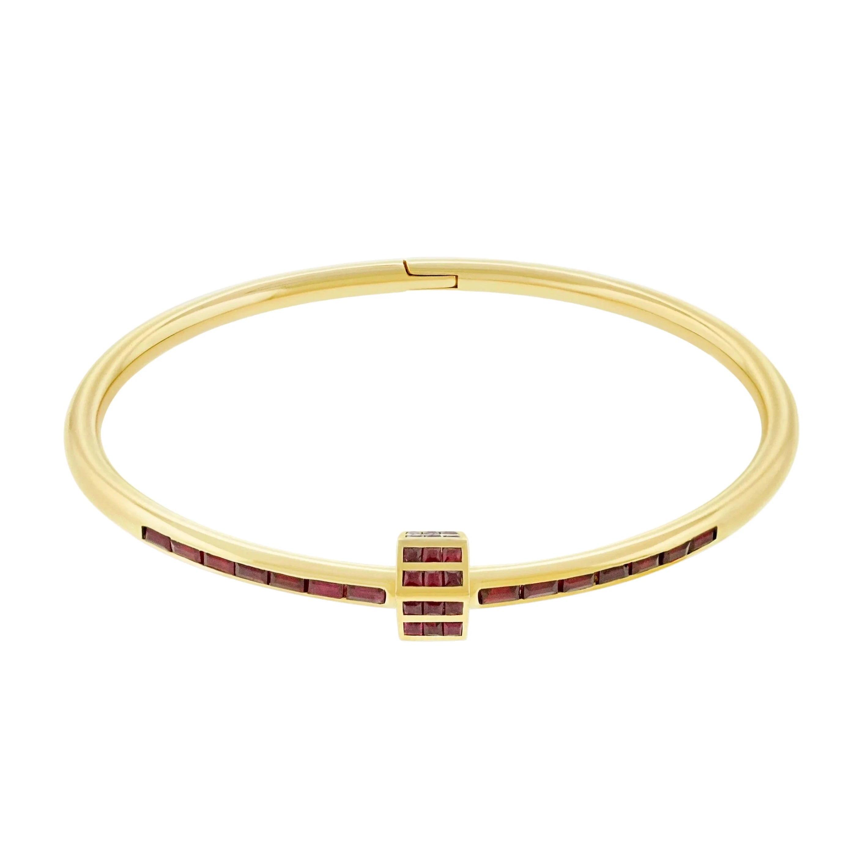 Gold bracelet with red stones on a white background