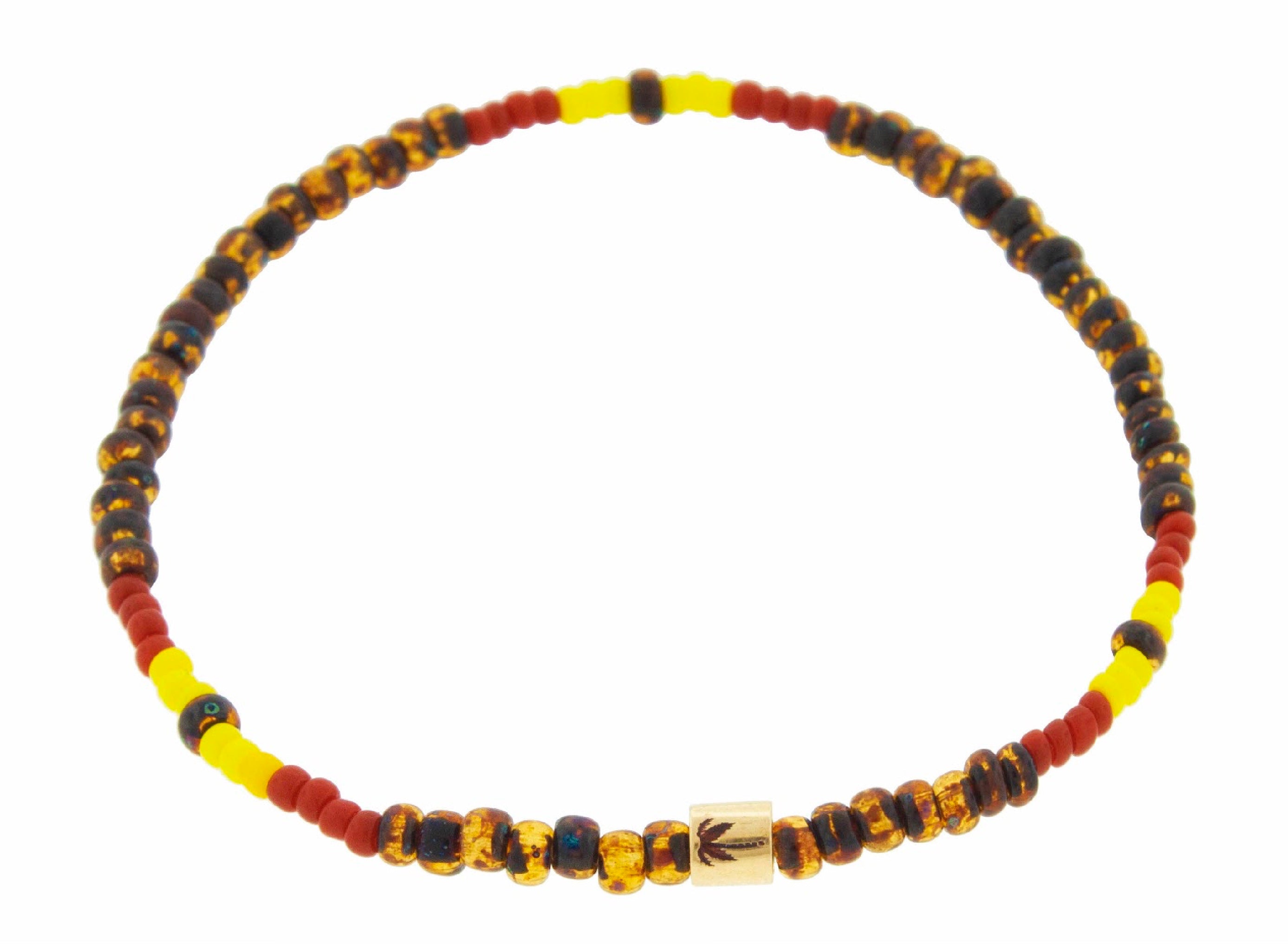 LUIS MORAIS 14K yellow gold short roll with antiqued palm tree  symbol on a tribal patterned glass beaded bracelet.