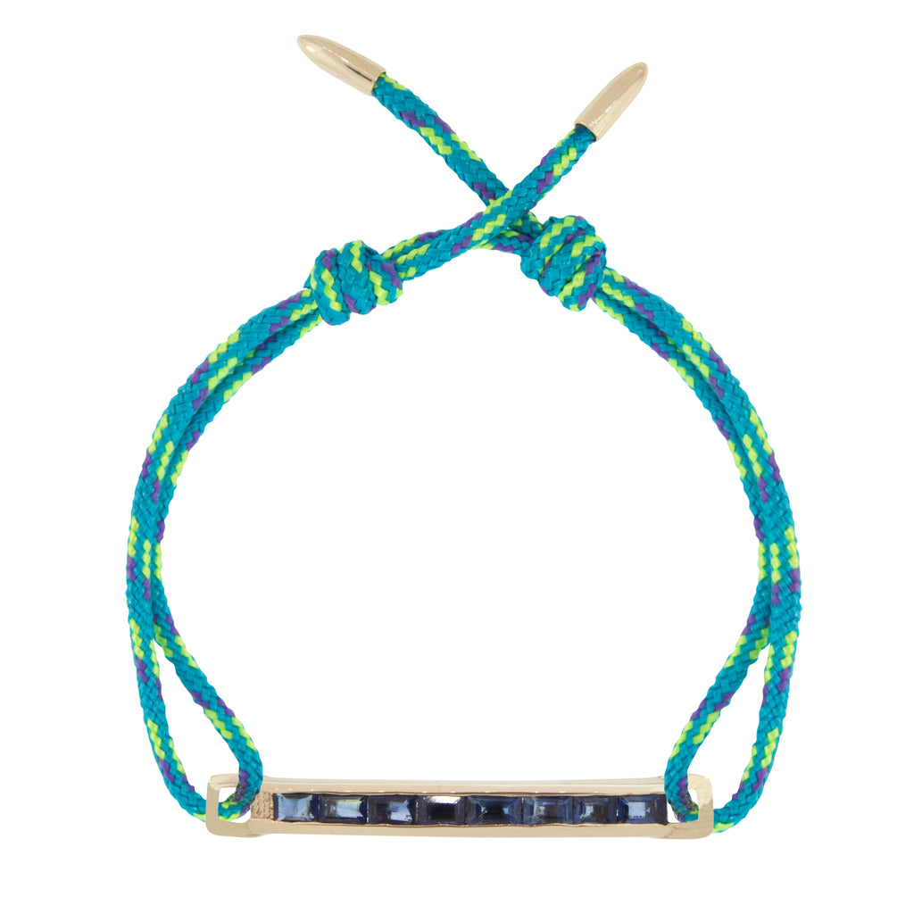 LUIS MORAIS 14K gold medium link bar with blue sapphire baguettes and bullet tip ends on an adjustable cord bracelet.