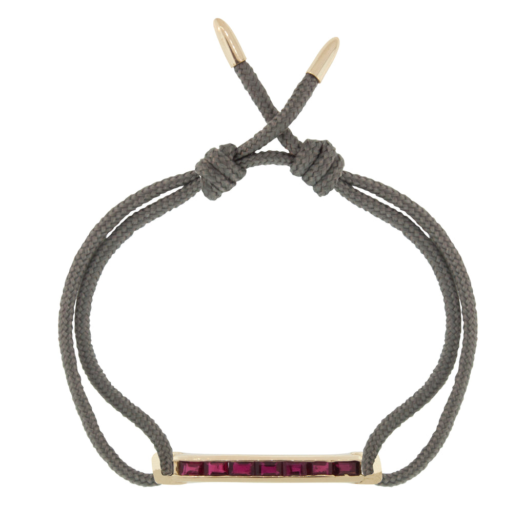 LUIS MORAIS 14K gold medium link bar with ruby baguettes and bullet tip ends on an adjustable cord bracelet.