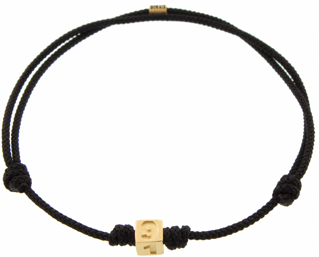 LUIS MORAIS 14K yellow gold cube with engraved 310 area code and a white diamond on an adjustable cord bracelet.
