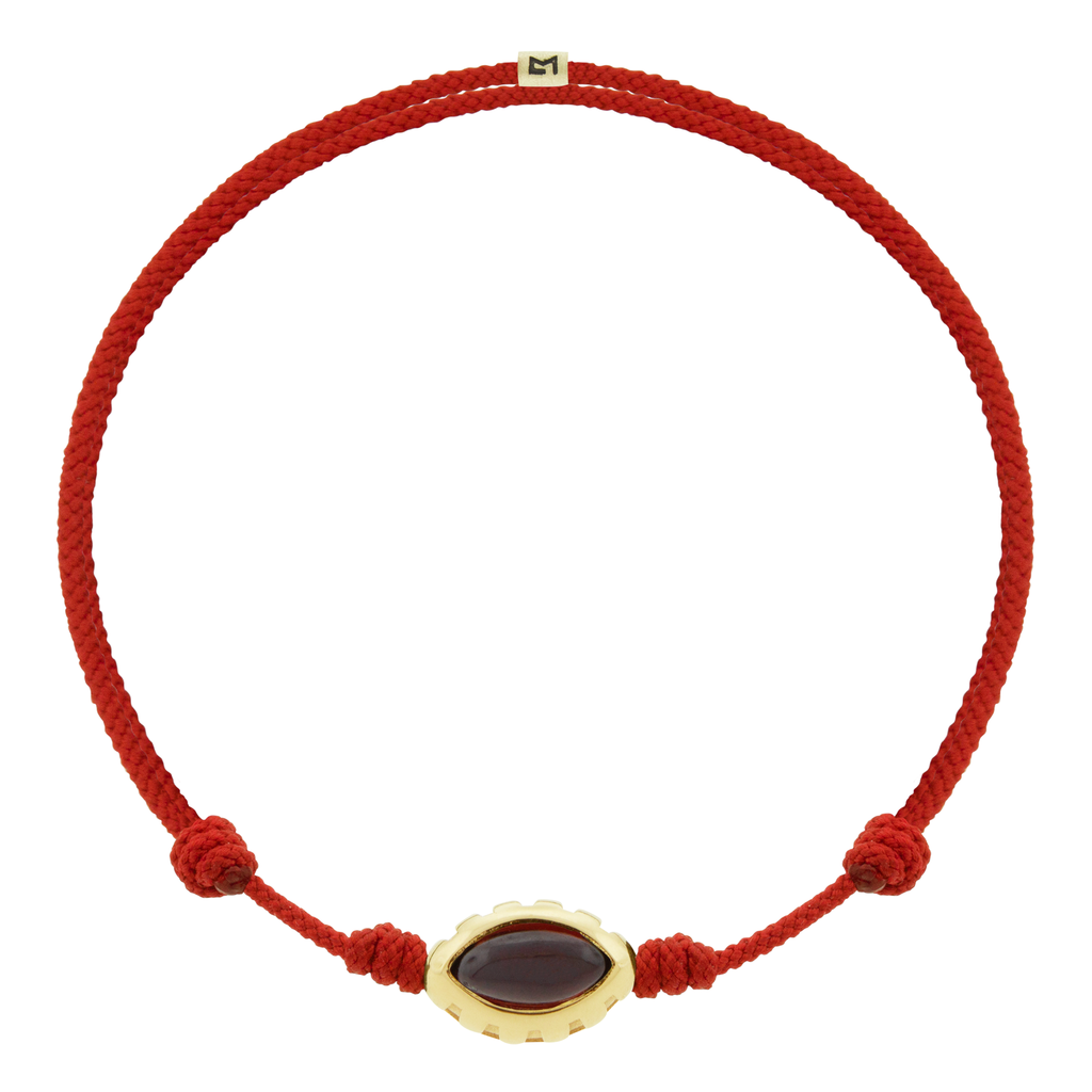 LUIS MORAIS 14k yellow gold Eye of the Idol bead with a marquise Garnet gemstone on a red cord bracelet.