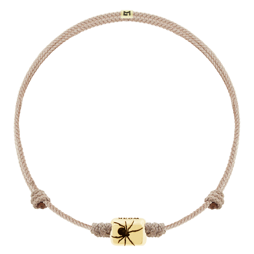 LUIS MORAIS 14k yellow gold ingot with a recessed spider symbol and antiqued sayings on an adjustable cord bracelet.
