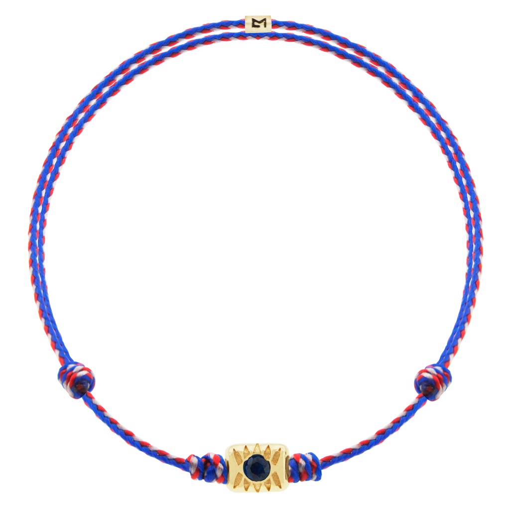 LUIS MORAIS 14k yellow gold eye ingot with a round blue Sapphire center on an adjustable cord bracelet.