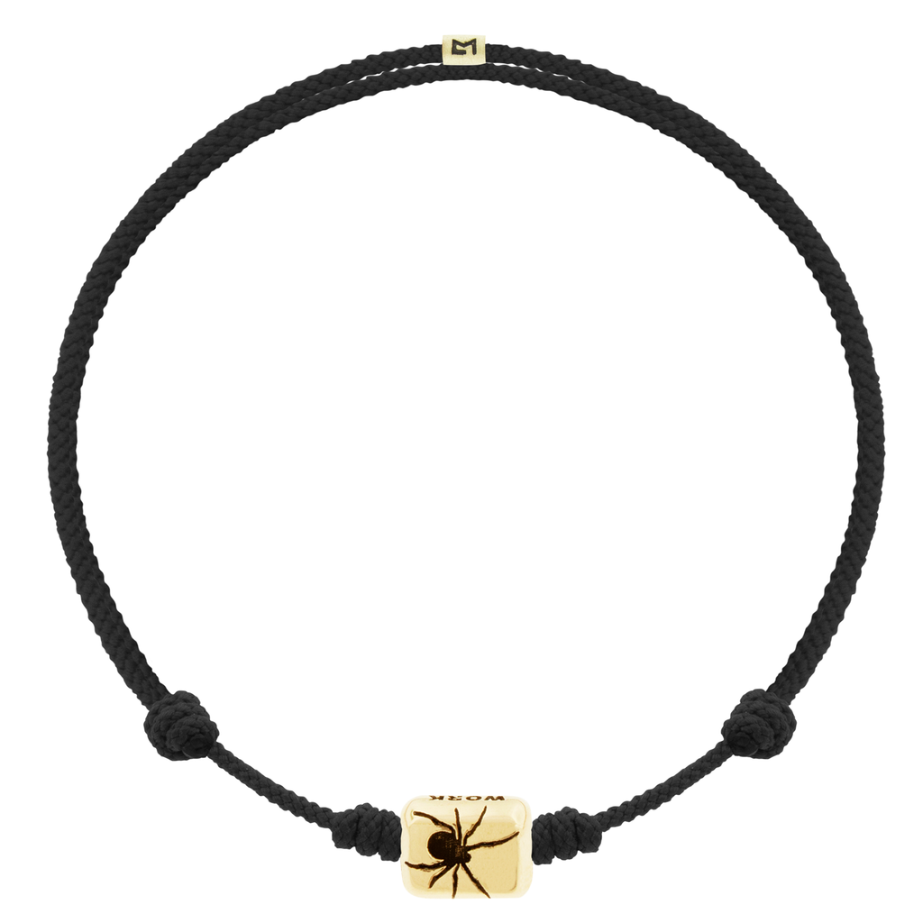 LUIS MORAIS 14k yellow gold ingot with a recessed spider symbol and antiqued sayings on an adjustable cord bracelet.
