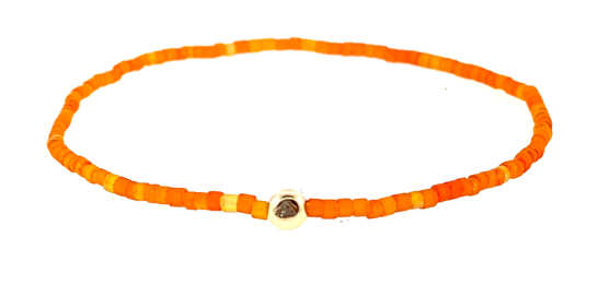 Boule d'or avec diamant blanc sur bracelet de perles de verre