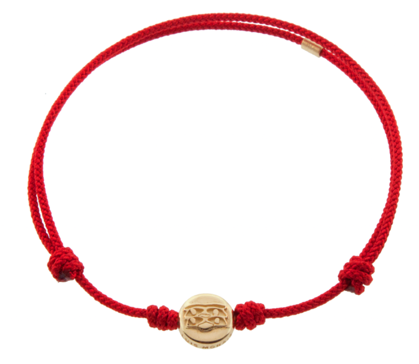 LUIS MORAIS 14K yellow gold small disk with a triple Horus eyes symbol on a red cord bracelet. The symbol is on both sides of the gold.