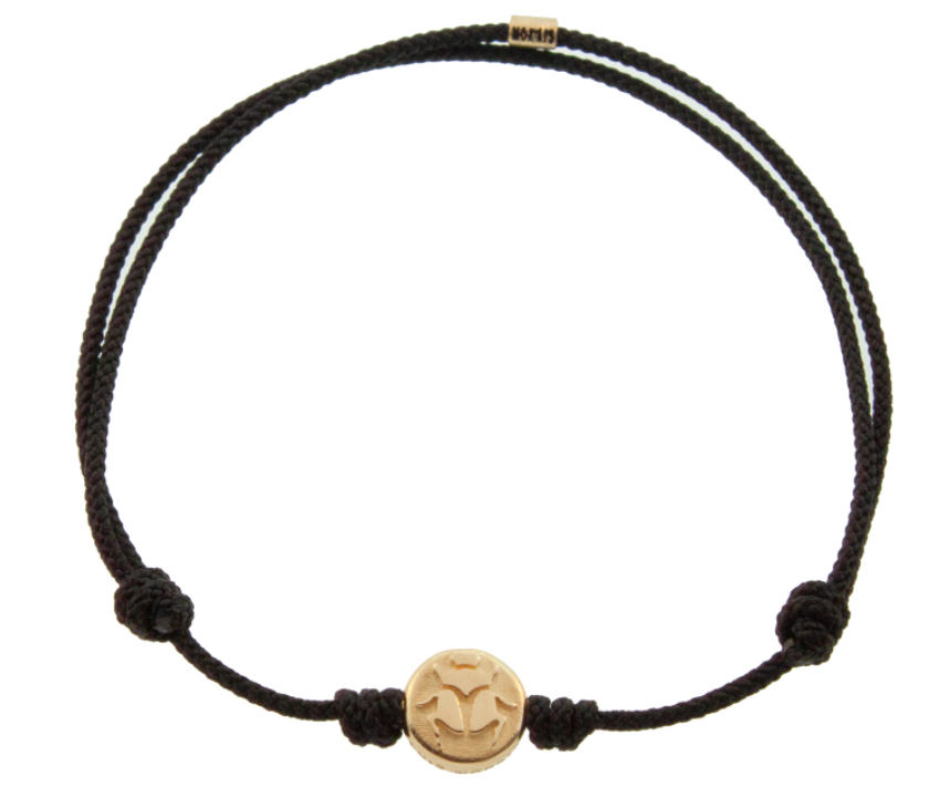 LUIS MORAIS 14K yellow gold small disk with a scarab symbol on a black cord bracelet. The symbol is on both sides of the gold.