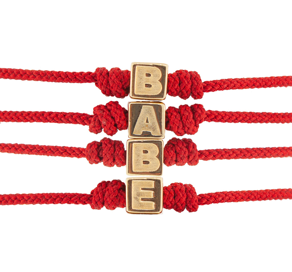 LUIS MORAIS 14k gold BABE cube on a red  adjustable cord bracelet.